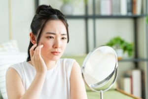 鏡を見て悩む女性